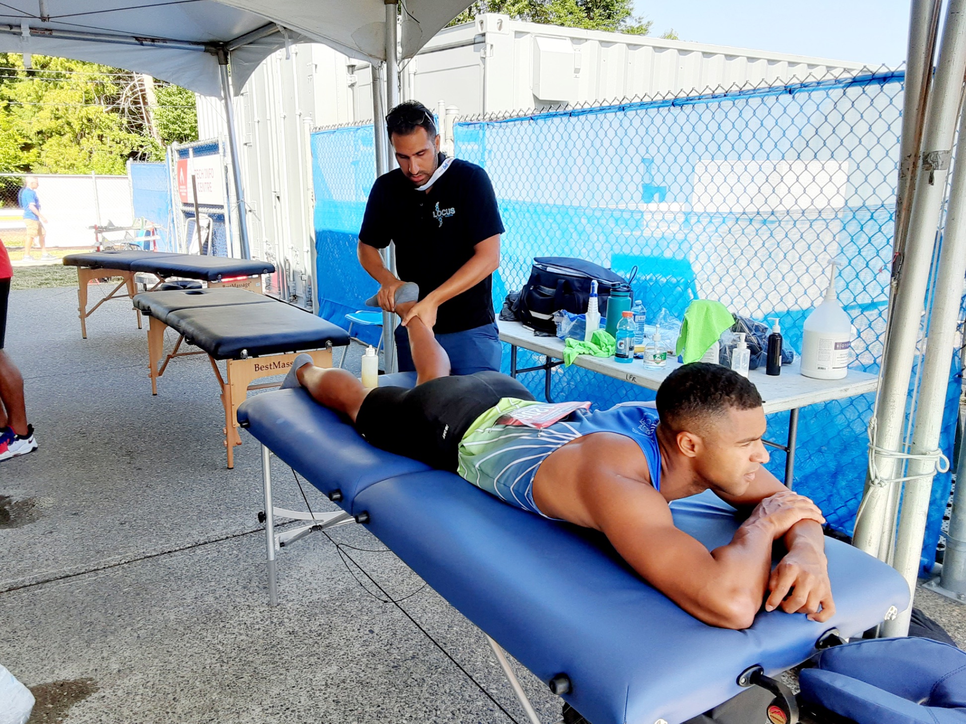 Locus Health practitioner providing massage therapy at outdoor athletic event