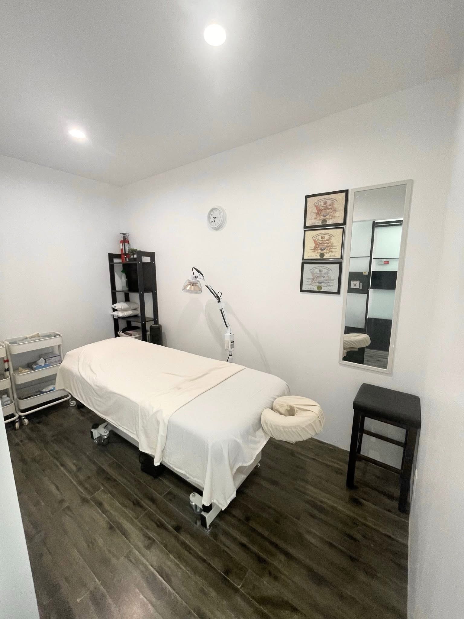 Clean private treatment room with massage table and practitioner certificates