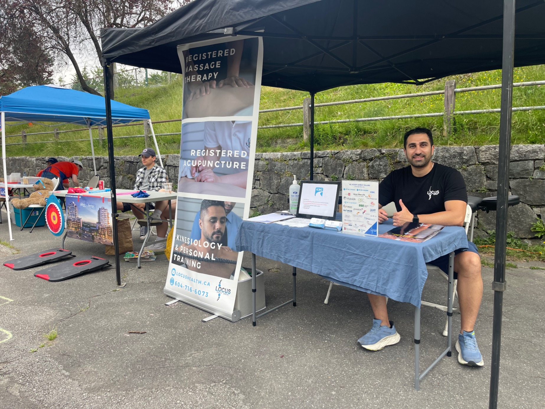 Locus Health booth at community event with RMT and acupuncture banner